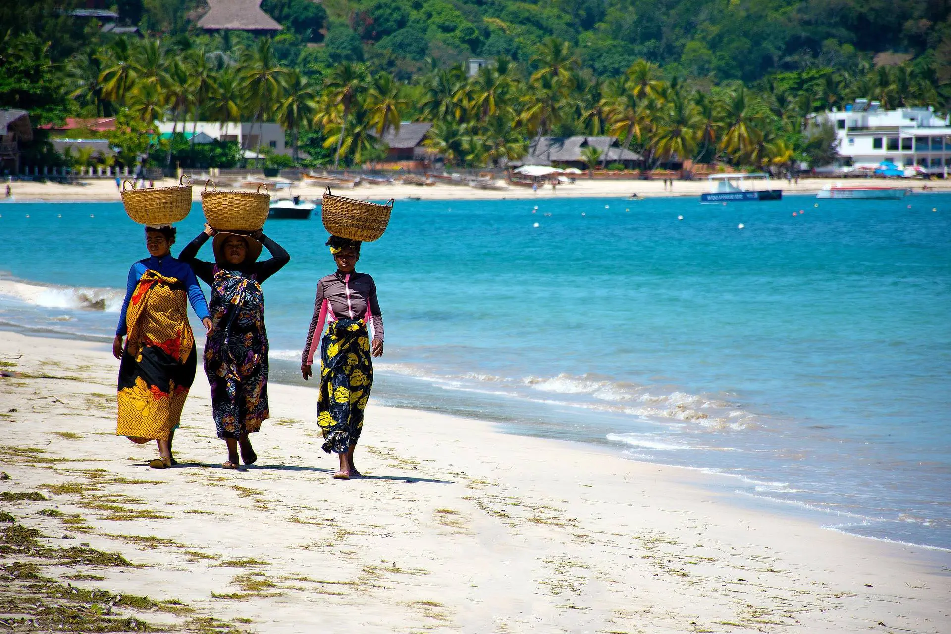 Femmes le long de la plage qui portent des paniers