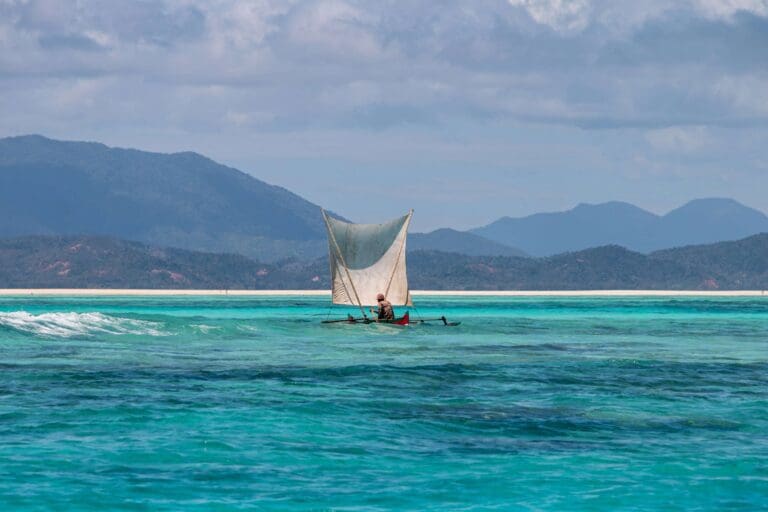 Pirogue met zeil op de turquoise zee